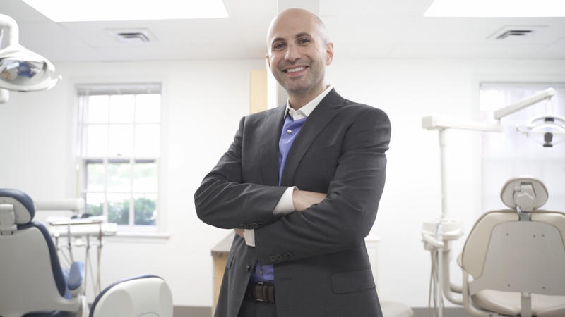 Dr. Dahman smiling with folded arms