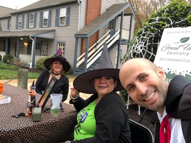 A vampire and two witches at a table in a neighborhood