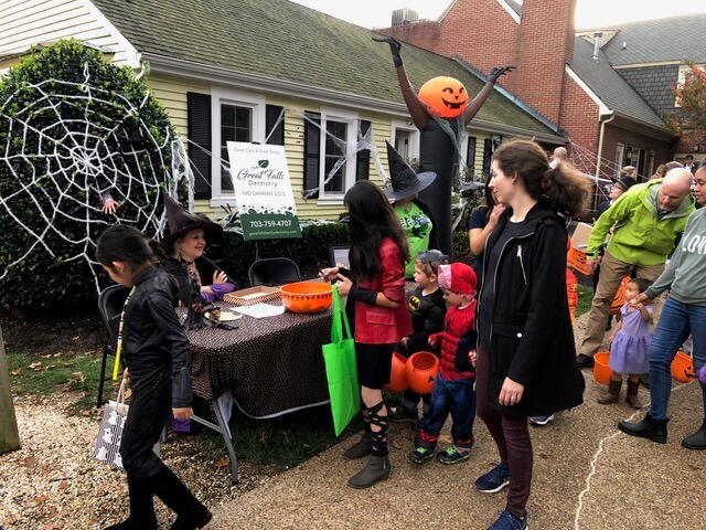 A family in costume walks past our halloween table