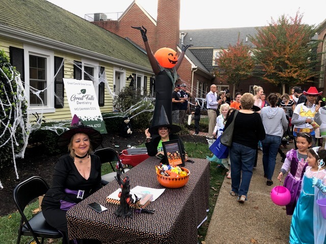 Our team members in costume at Halloween table looking at costumes