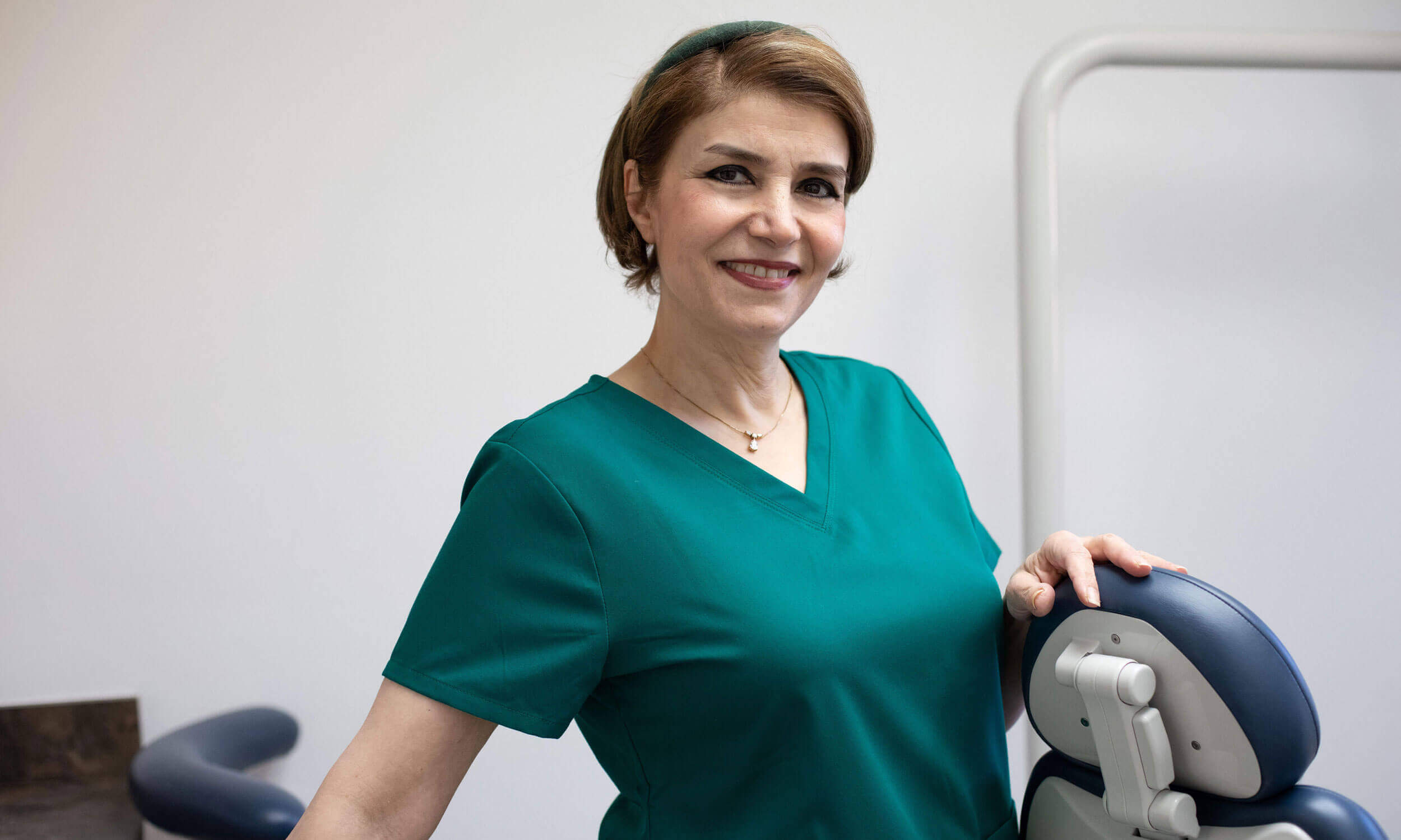 A team member standind by a dentist chair