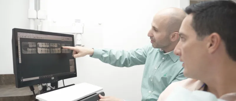 Dr. Dahman with a patient showing the patient his X-rays of his teeth