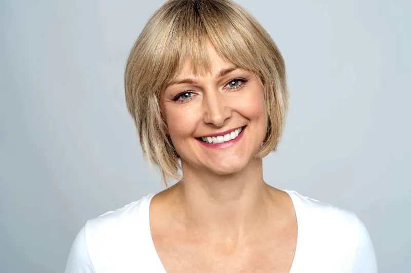 A woman in a white shirt smiling